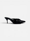 Black high-heeled shoe with a bow on a white background