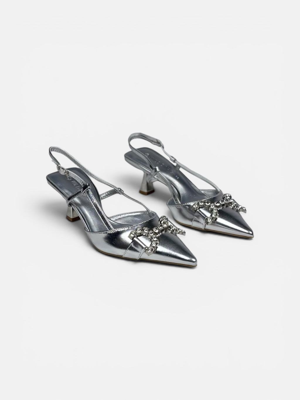 Pair of silver high-heeled shoes with embellishments on a white background