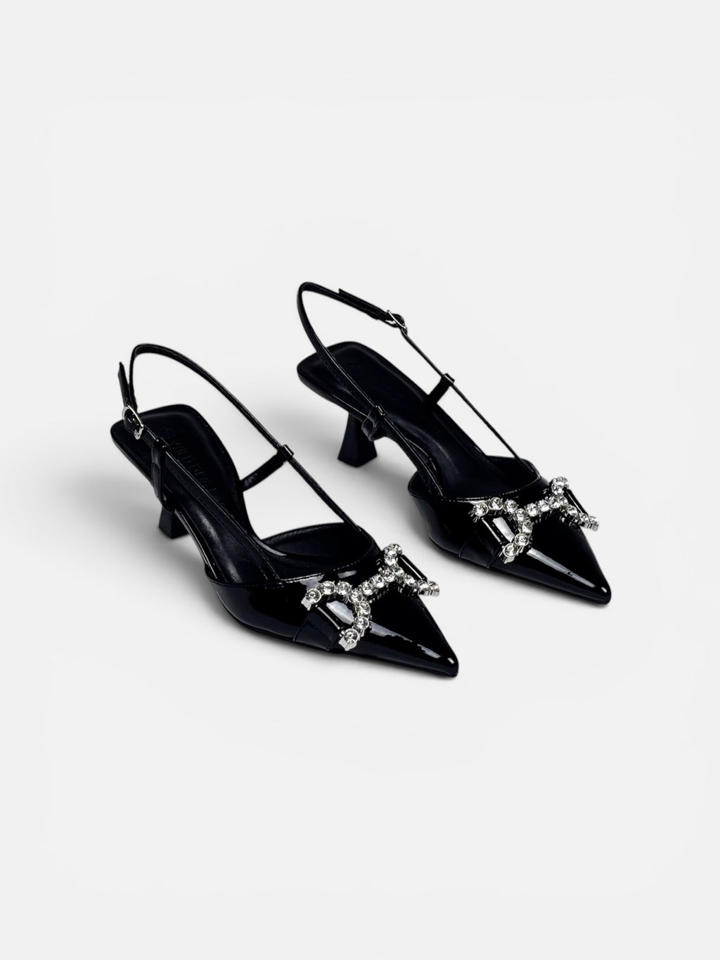 Black high-heeled shoes with decorative elements on a white background