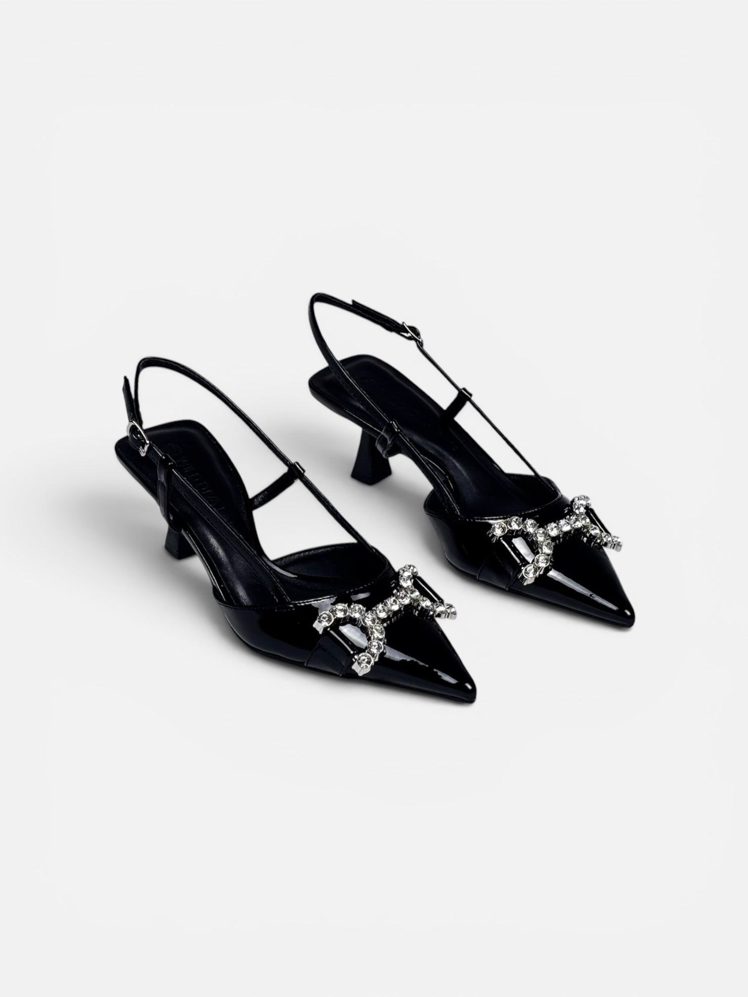 Black high-heeled shoes with decorative elements on a white background