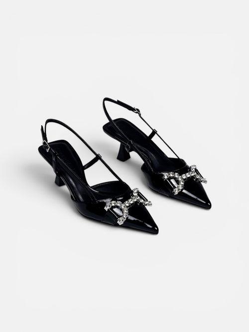 Black high-heeled shoes with decorative elements on a white background